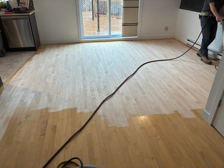 Hardwood floor mid-sanding in a kitchen